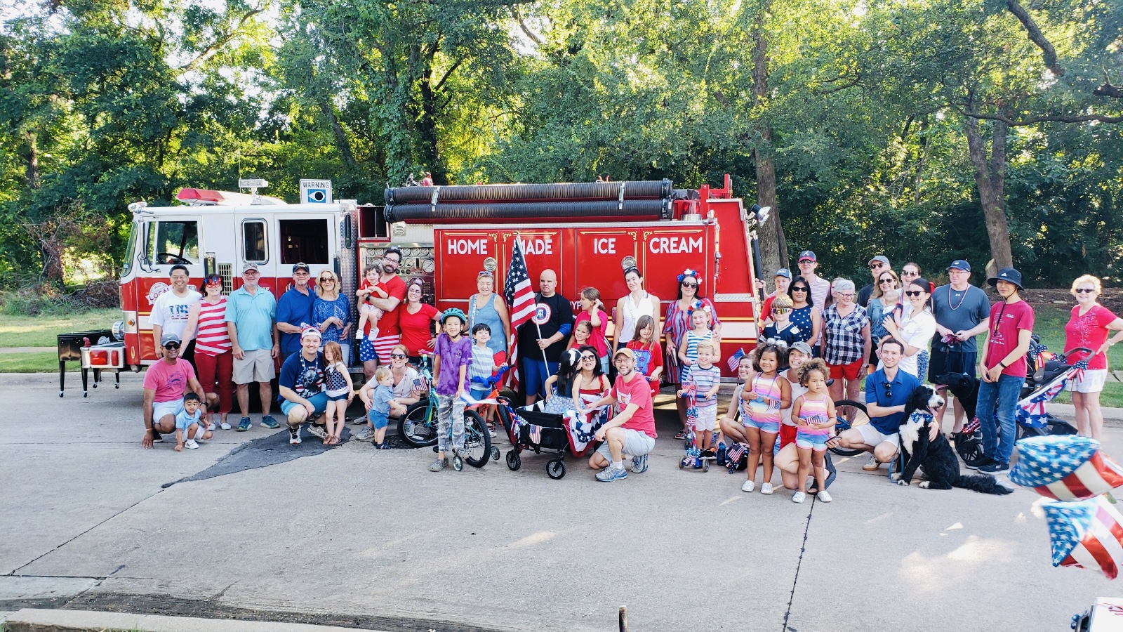 Image of Local Creamery's ice cream fire truck, Big Dipper, at a neighborhood night out with adults and kids eating ice cream.