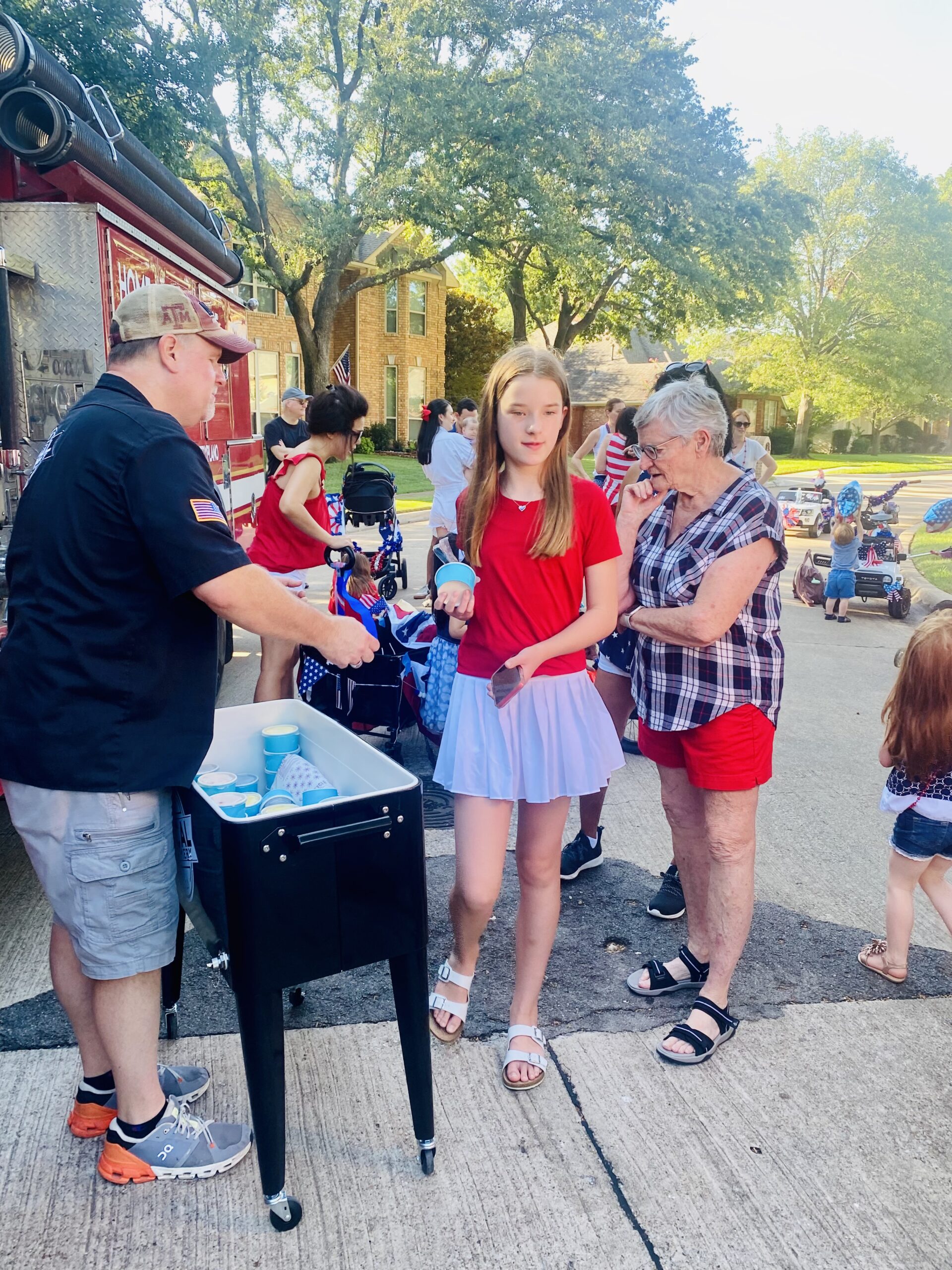 Image of Local Creamery owner, Lane, serving single scoop ice cream at a neighborhood night out. 